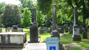 Photo of a graveyard with an apparent tomb in front and three column markers behind