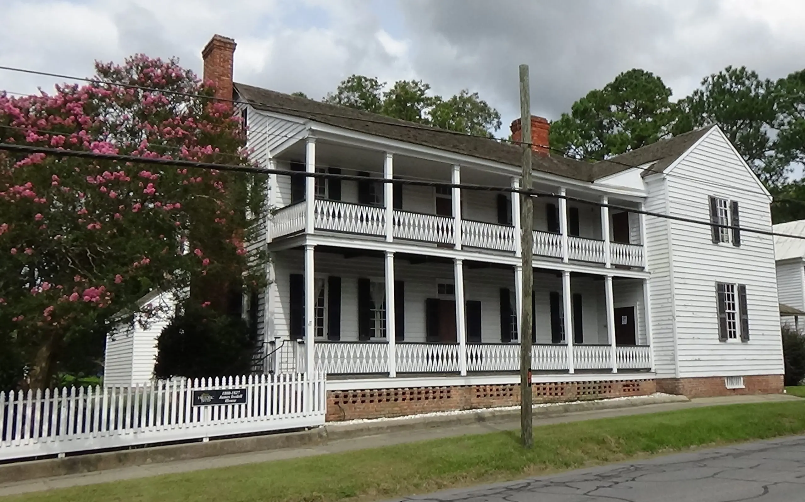 Photo of a white house with matching porches on two stories