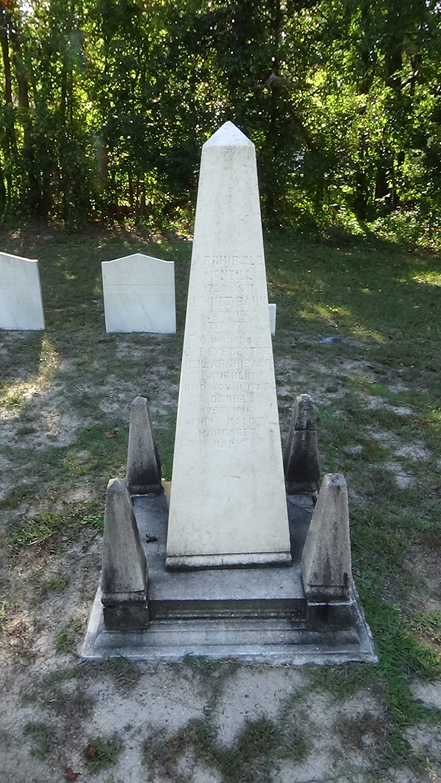 Marble obelisk on a darkened base with small ones on each corner