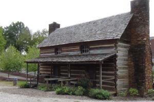 Photo of a two-story log cabin with a front porch