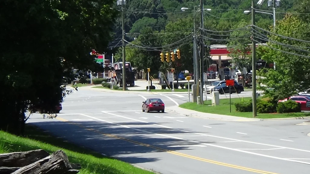 Photo looking down a three-lane road into a major intersection