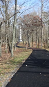 Photo of a path along an open ridge with a obelisk-shaped monument in the distance