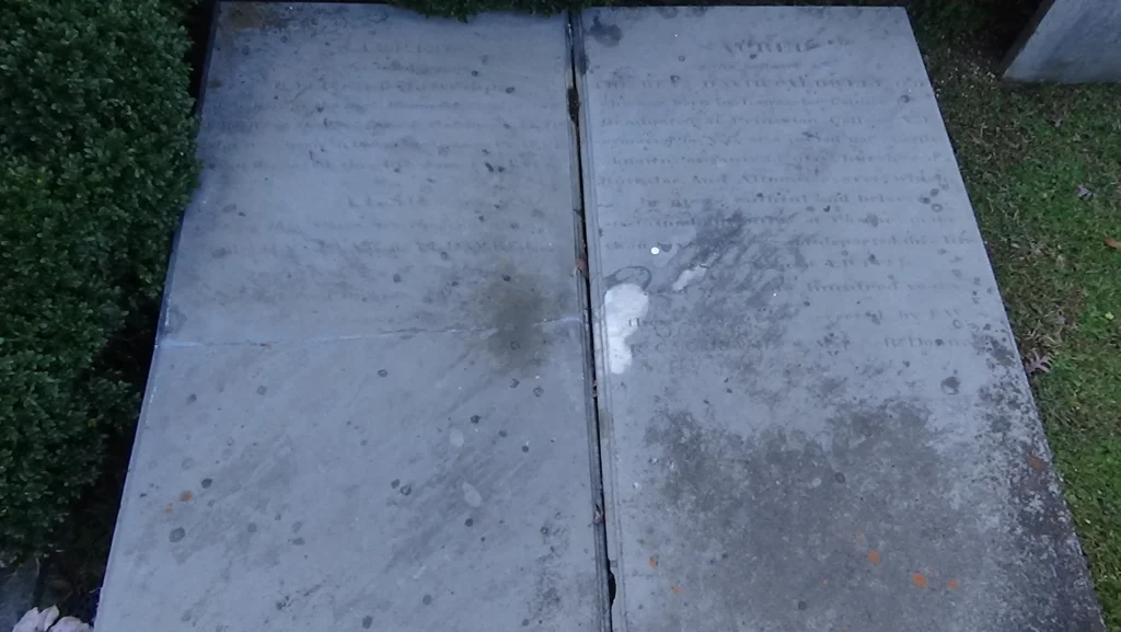 Two flat, body-length gravestones raised off the ground