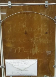 Photo of brown backing of portrait with faded white writing on it