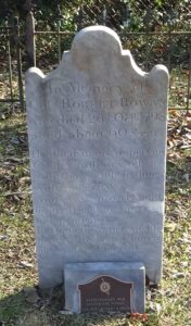 Photo of a gravestone with a small American Revolution marker in front