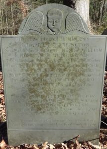 Photo of a tombstone with an angel's face and wings in the rounded top