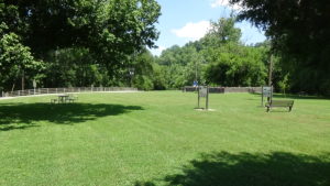 Photo of a grassy park with a wall around a monument